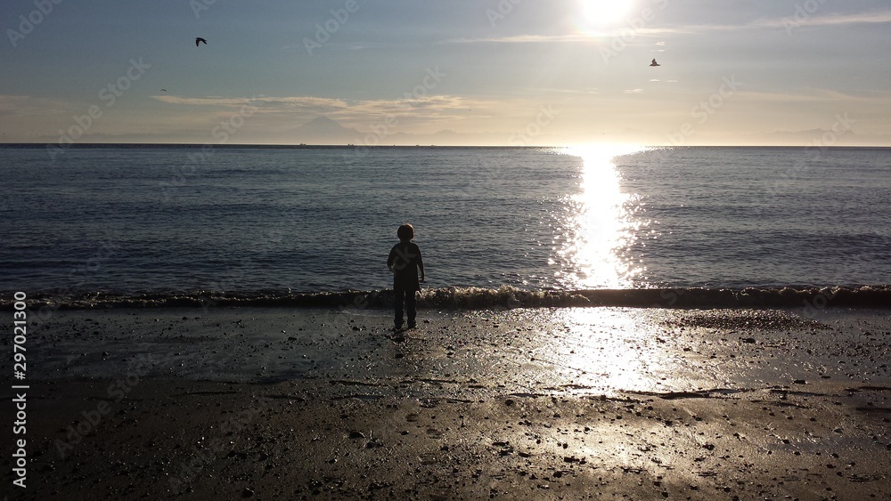 silhouette of a child on the beach at sunset