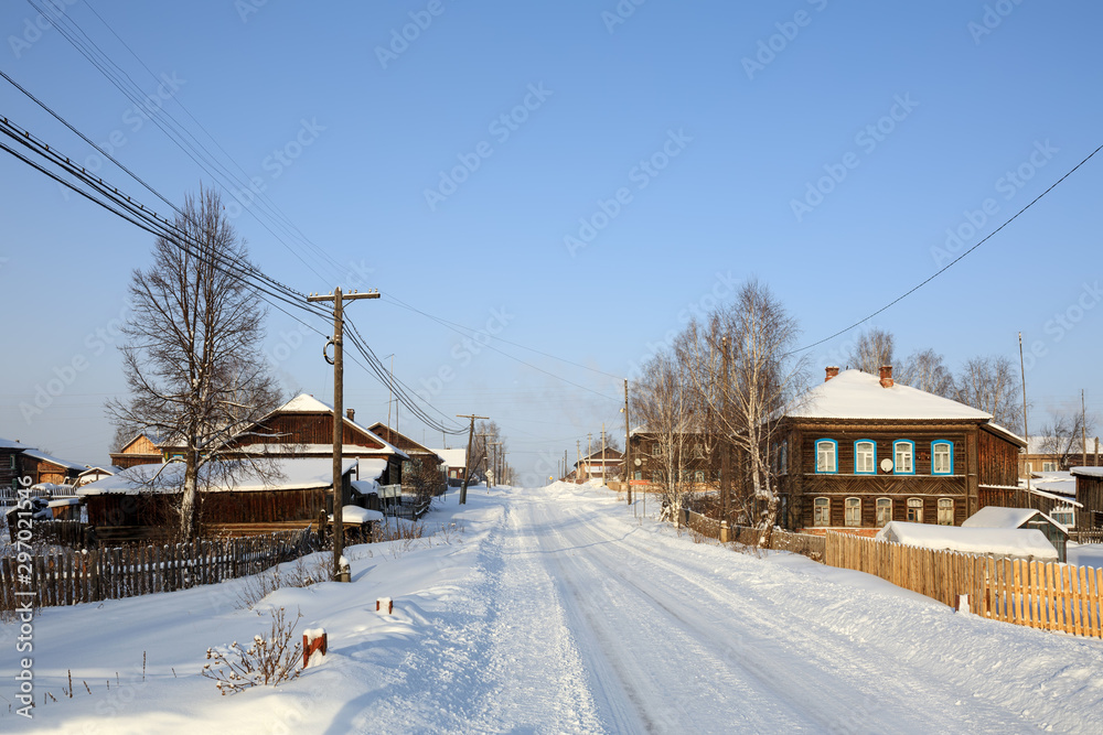 Snow-covered country road in winter. View of the old residential neighborhood. Village of Visim, Sverdlovsk region, Urals, Russia