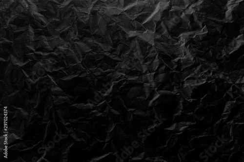 Old crumpled texture black cardboard sheet of empty paper black background.