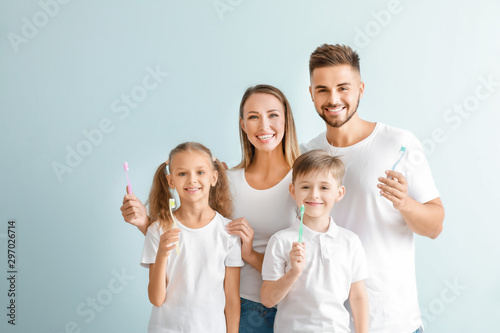 Portrait of family with toothbrushes on light background