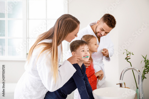 Family brushing teeth in ba...