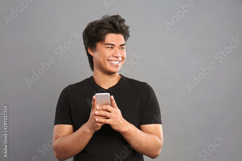 Smiling young asian man hol...