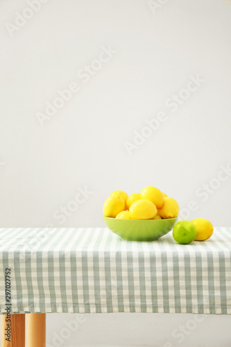 Bowl with ripe lemons on table