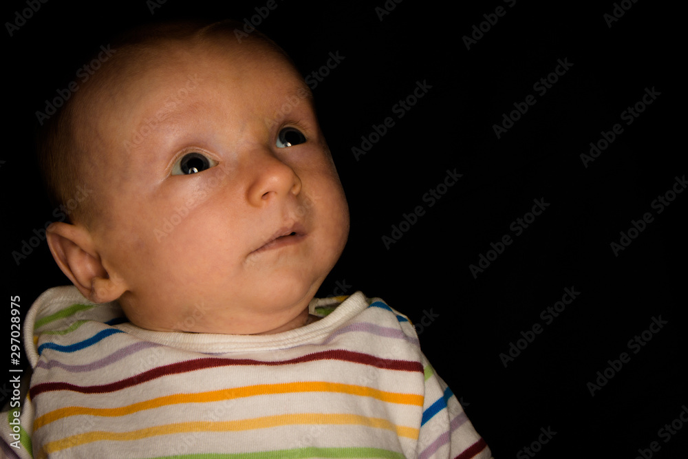 A 2 Month Old Baby Poses on a Black Background. Perfect for Memes with Copy Space.