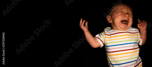 A 2 Month Old Baby Poses on a Black Background. Perfect for Memes with Copy Space.
