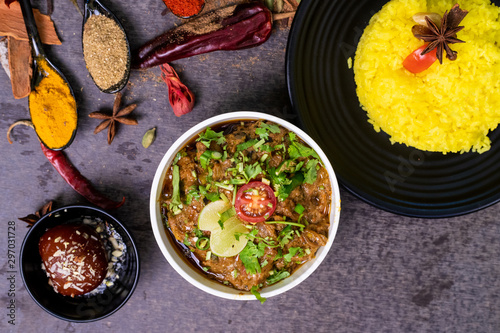 Indian rice with spices and Cachew/Kaju and gulab jamun served with spicy chicken curry, selective focus with copy space. photo