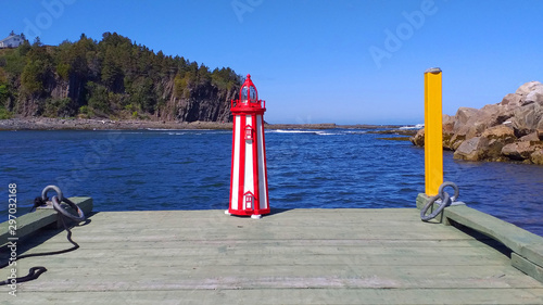 Miniature reproduction of white and red lighthouse on a pier at the St Lawrence river Gaspésie Québec Canada photo