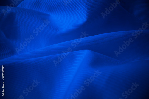 Shiny flowing cloth texture in macro shot. Wavy clean silk weave material. Textile abstract background. photo