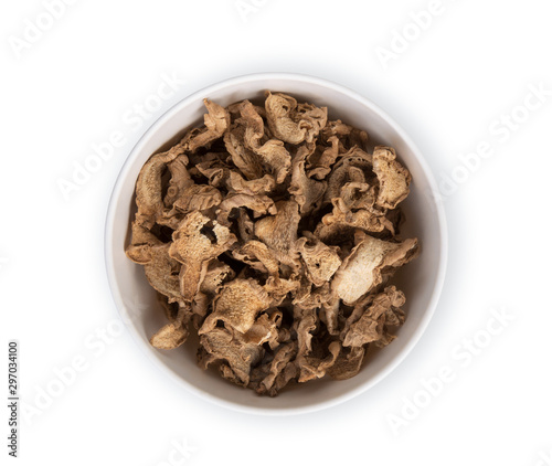 dried ginger in the white bowl isolated on white background, top view, flat lay