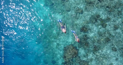 Swimmers in turquoise water, aerial shot. Exploring coral reefs. Stunning travel shot, Maldives.