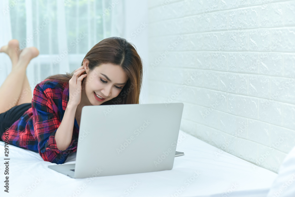Young woman holding credit card and using laptop computer. Online shopping concept Young woman holding credit card and using laptop computer. Online shopping concept