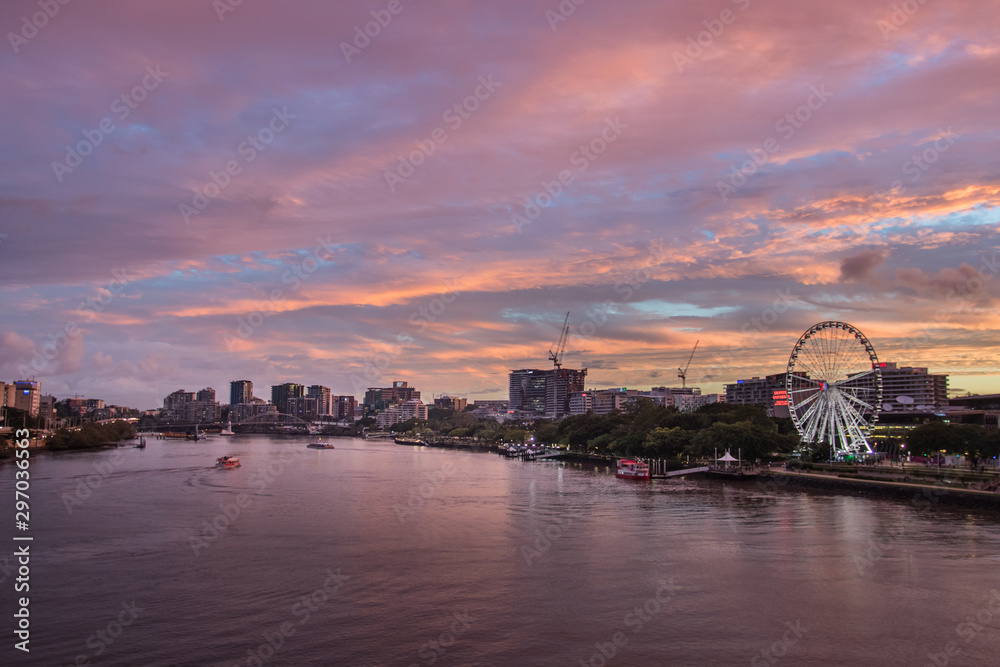 Brisbane City River At Sunset With A Dramatic Pink Pastel Sky With Buildings And The Ferris Wheel In The Distance