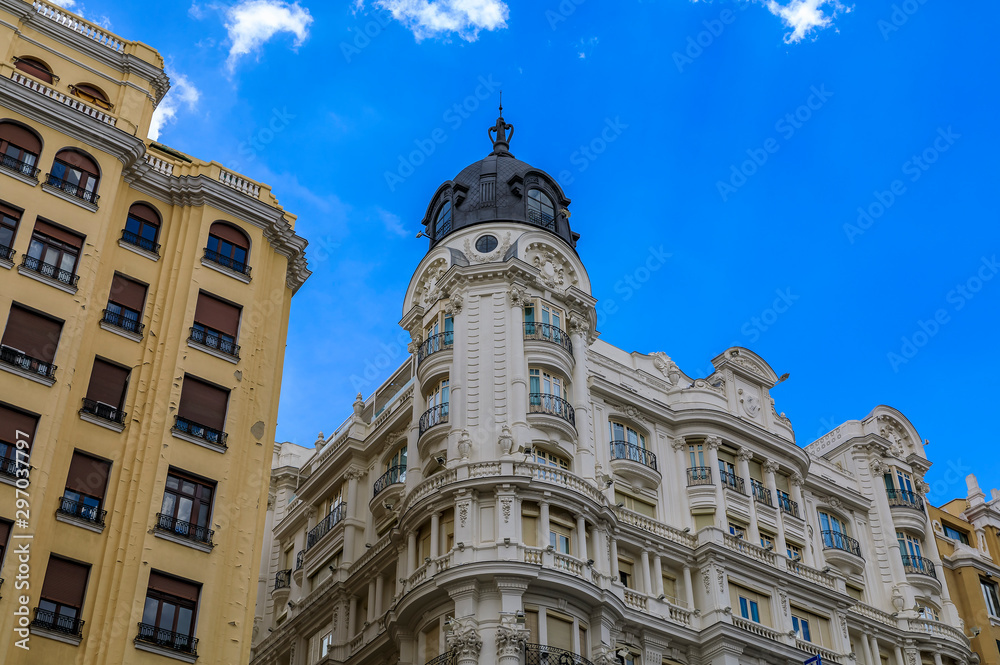 Facades of beautiful buildings on Gran Via shopping streets in the center of the city in Madrid, Spain