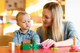 Mother and child son are talking and smiling while playing with educational toys at home