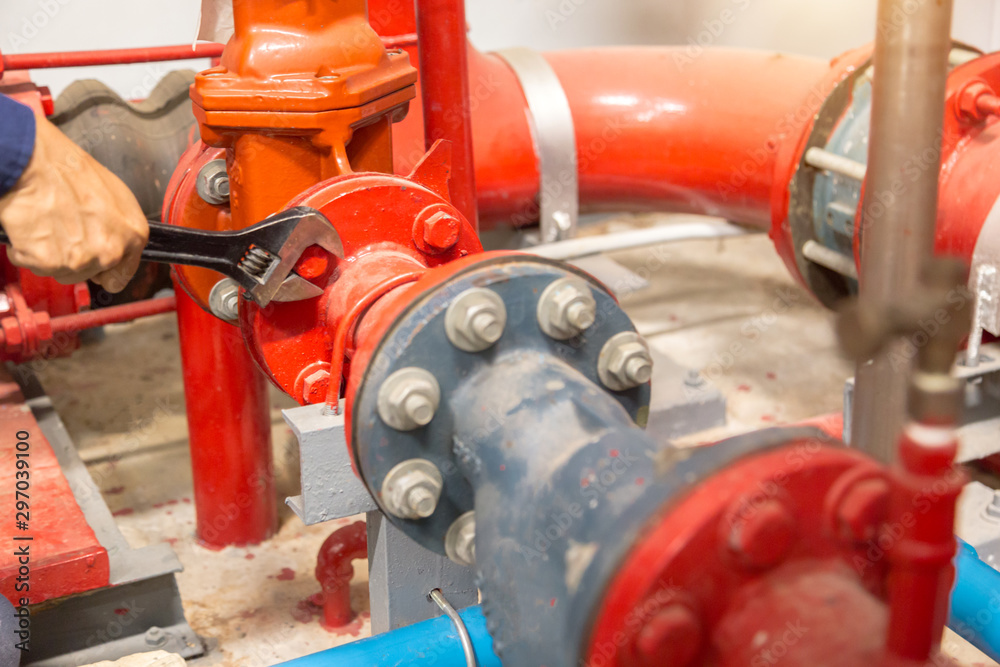 Plumber repairing and performing maintenance big water pipes.