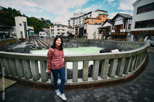 Asian girl is standing at Yabatake what is natural hot spring at Kasatzu Onsen, Gunma, Japan. photo