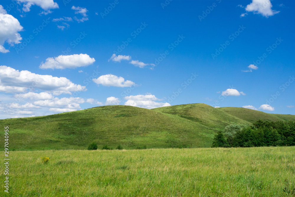 Green hills and blue sky with clouds. Beautiful summer landscape. Green hills and blue sky with clouds. Beautiful summer landscape.