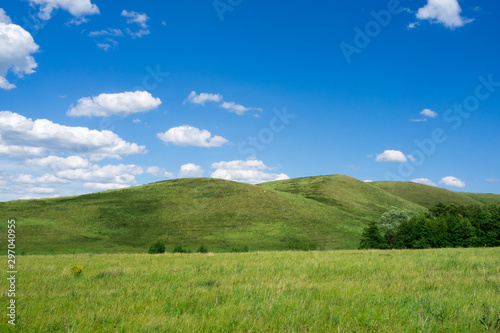 Green hills and blue sky with clouds. Beautiful summer landscape.