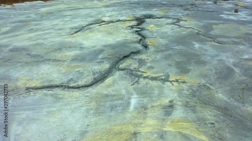 Aerial view; drone flying forward over a polluted river with destroyed ecosystem and copper tailing dump poisoning ground and water; air emissions from industry; environmental disaster in South Ural photo