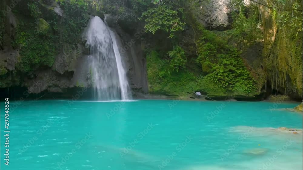 Kawasan Falls on Cebu Island, Philippines. Beautiful waterfall in tropical rain forest.Waterfall with natural swimming pool and bamboo raft in a mountain river canyon. Kawasan Falls on Cebu Island, Philippines. Beautiful waterfall in tropical rain forest.Waterfall with natural swimming pool and bamboo raft in a mountain river canyon.