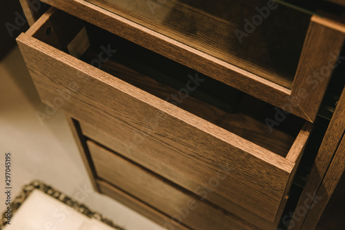 Wooden cupboard with opened empty drawer.