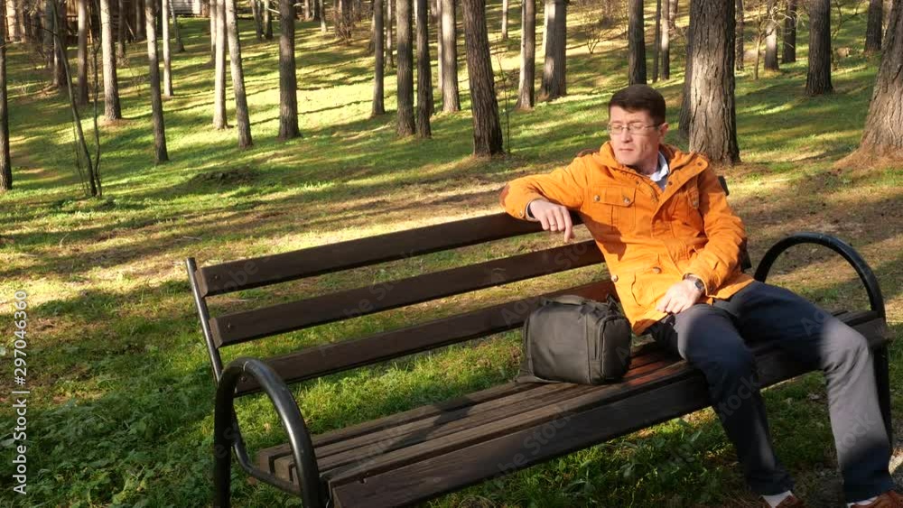 A man in the park sitting on a bench.