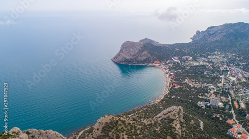 Fototapeta Naklejka Na Ścianę i Meble -  Quiet sea bay with a city on the shore surrounded by mountains and rocks