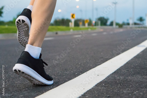 Movement. Woman legs running on asphalt road.