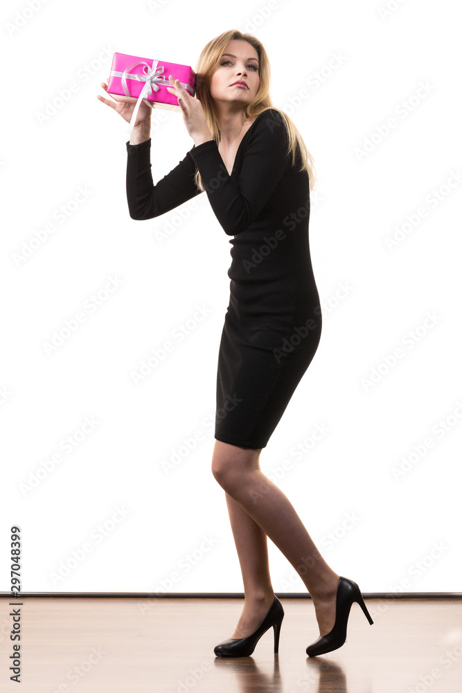 Girl holding present shaking pink gift box Girl holding present shaking pink gift box