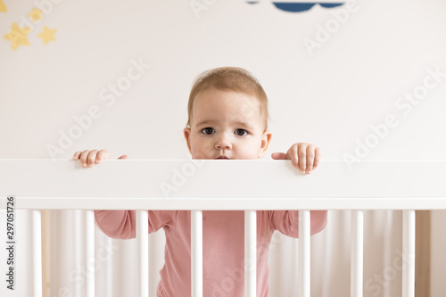 Baby girl standing in bed  