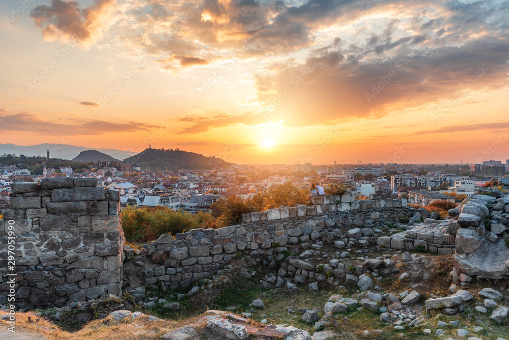 Part of ancient fortress wall on top of the Nebet tepe Hill in Plovdiv city, Bulgaria. Panoramic view with warm sunset. Autumn day. Ancient Plovdiv is UNESCO's World Heritage.