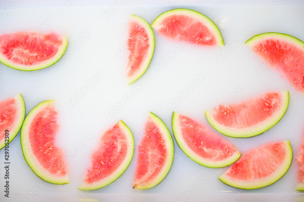 Turbid soapy water in bath with slices of watermelon. top view in full frame. The largest berry. spa with milk in the bath for rejuvenation.. Turbid soapy water in bath with slices of watermelon. top view in full frame. The largest berry. spa with milk in the bath for rejuvenation..
