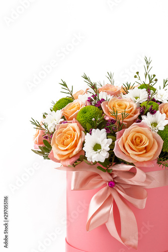 Beautiful bouquet in a coral luxury present box with a pink bow, isolated on white background