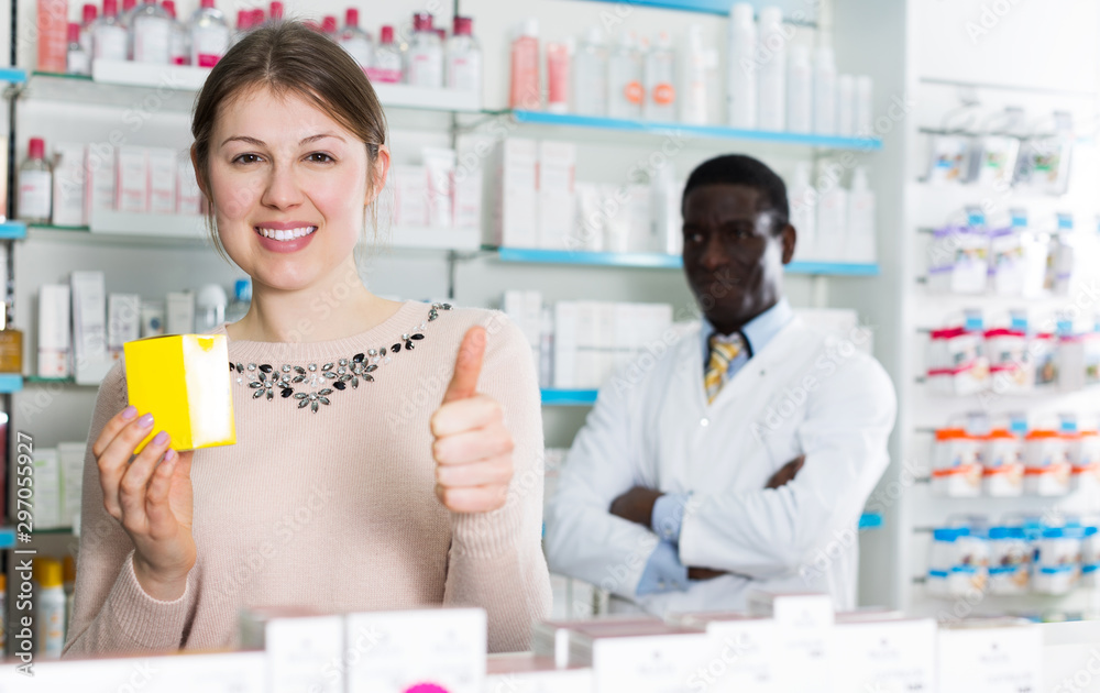 Satisfied woman with medicines showing thumb up
