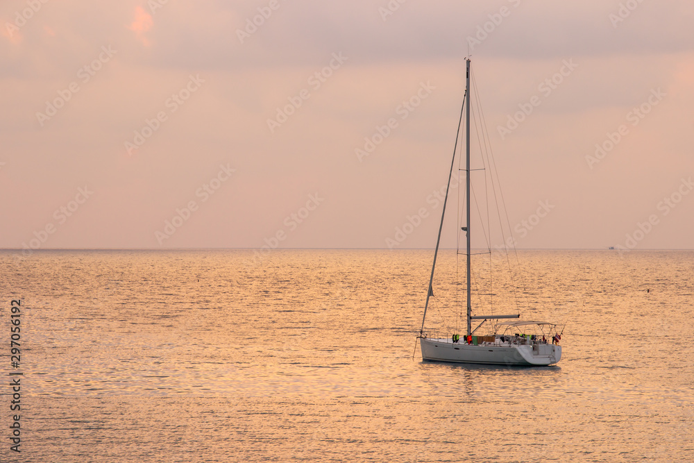 White sailboat of tourist at the background with sunset sky on the Ao thai sea area around haad bangbao of koh kood in trat province.Thailand.