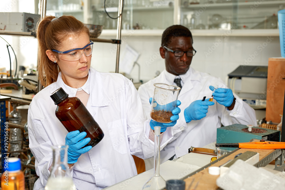 Fototapeta premium Young woman and man scientists working in research laboratory