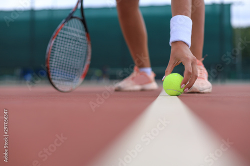 Tennis racket and the ball on tennis court. © ty