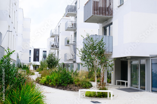 Sidewalk in a cozy courtyard of modern apartment buildings condo with white walls.