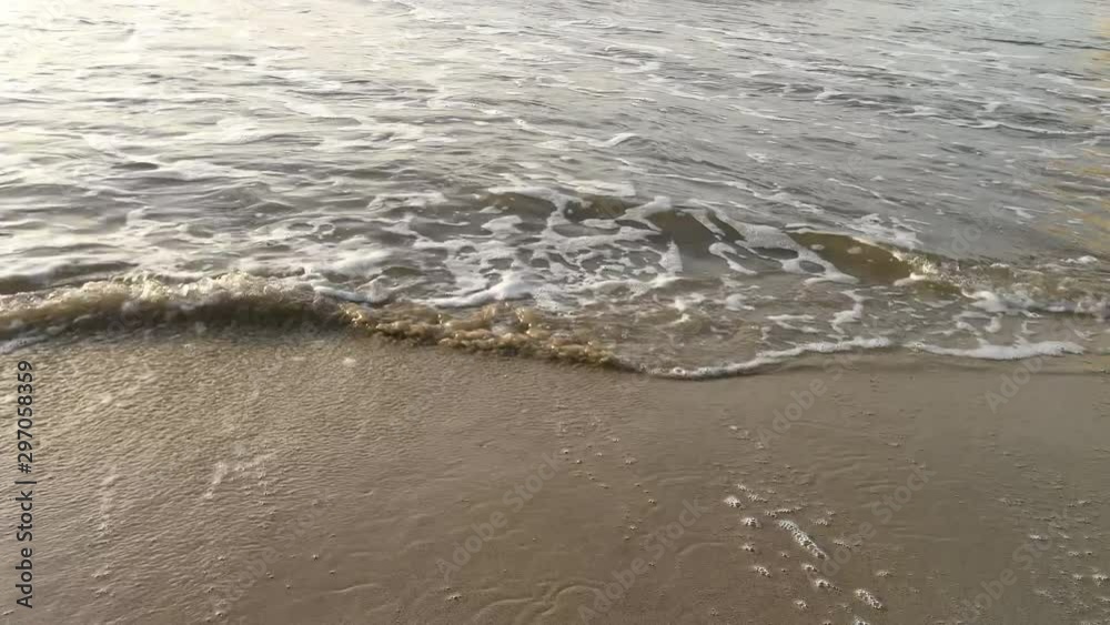 The waves reaching the sand of the beach and some going beyond the camera position The waves reaching the sand of the beach and some going beyond the camera position