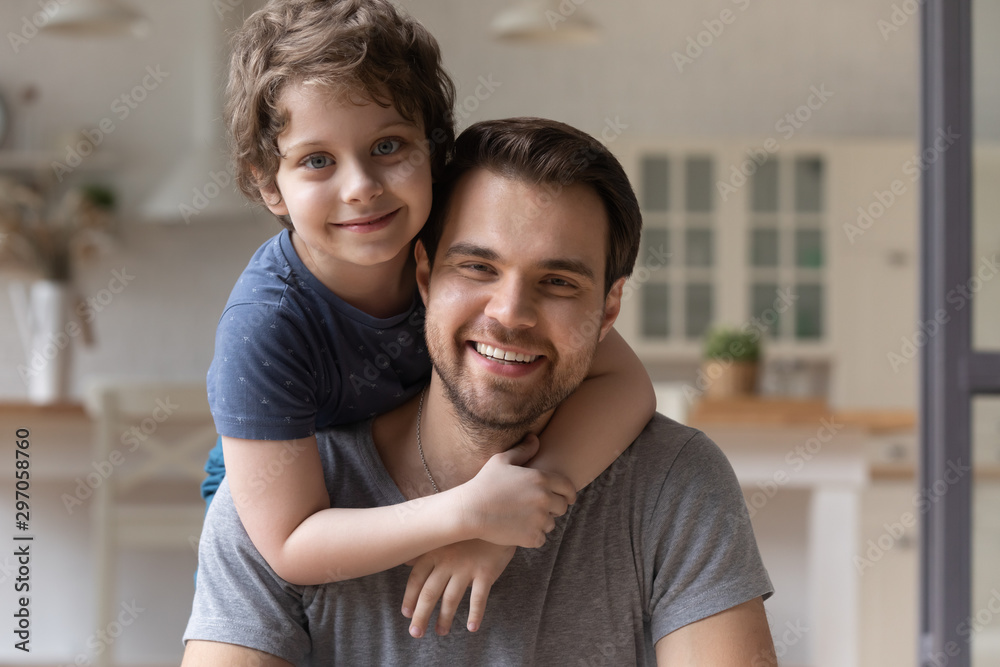 Head shot portrait happy father piggybacking cute little son Head shot portrait happy father piggybacking cute little son