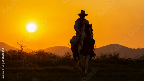 A lonely Cowboy riding horse  at sunset. © Samruay