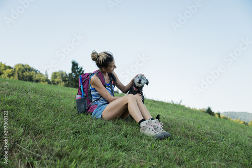 Young female hiker taking a break sitting in grass