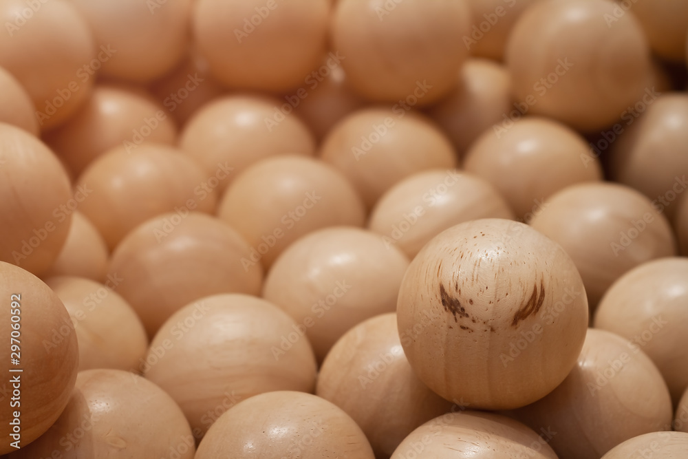 Wooden ball with pattern like brown eyebrow on face for insert emotion put around pattern less woodballs background. Photo for Leadership or Different thinking or Team work concept. Selective focus. Wooden ball with pattern like brown eyebrow on face for insert emotion put around pattern less woodballs background. Photo for Leadership or Different thinking or Team work concept. Selective focus.