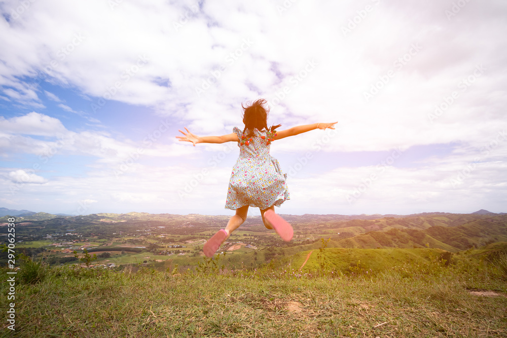 Happy active asian child girl jumping at the top of mountain Happy active asian child girl jumping at the top of mountain