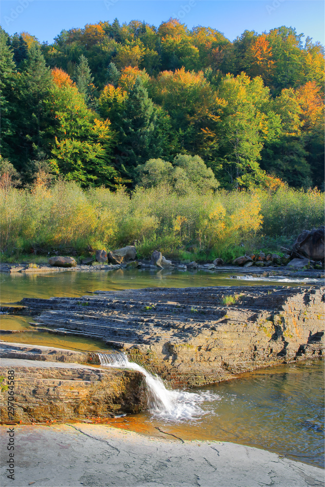 Waterfall on a mountain river in the autumn forest. Waterfall on a mountain river in the autumn forest.