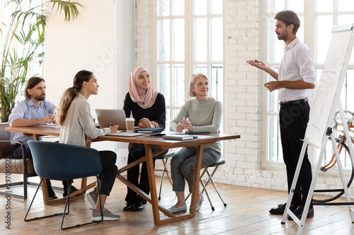 Confident businessman trainer give flip chart presentation at corporate training