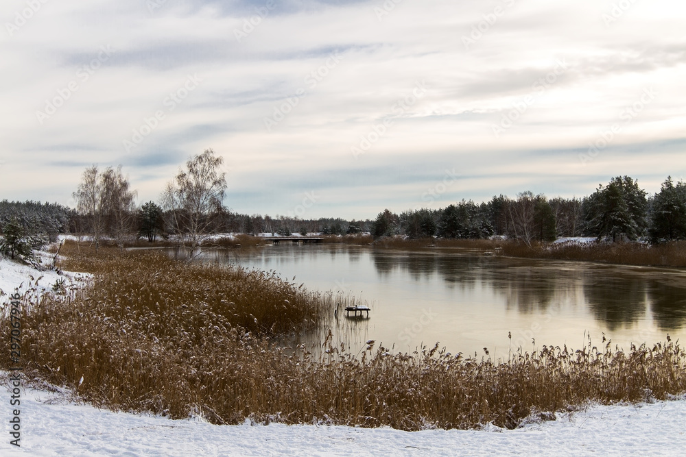 landscape. View from the shore of the river covered with thin ice. Winter.