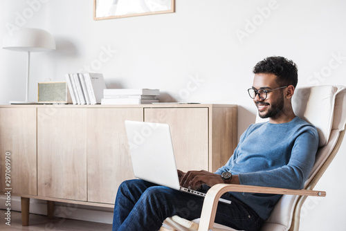 Handsome young man using laptop computer at home. Student men resting in his room. Home work or study, freelance concept	