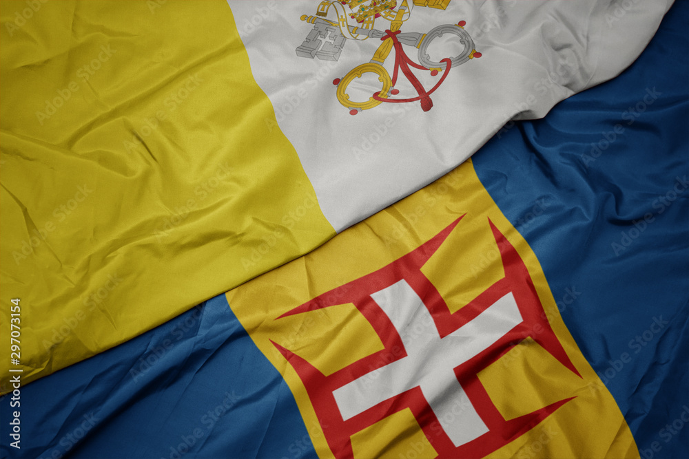waving colorful flag of madeira and national flag of vatican city. waving colorful flag of madeira and national flag of vatican city.