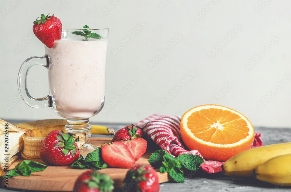 banana, strawberry and orange smoothies with mint on the table, front view banana, strawberry and orange smoothies with mint on the table, front view